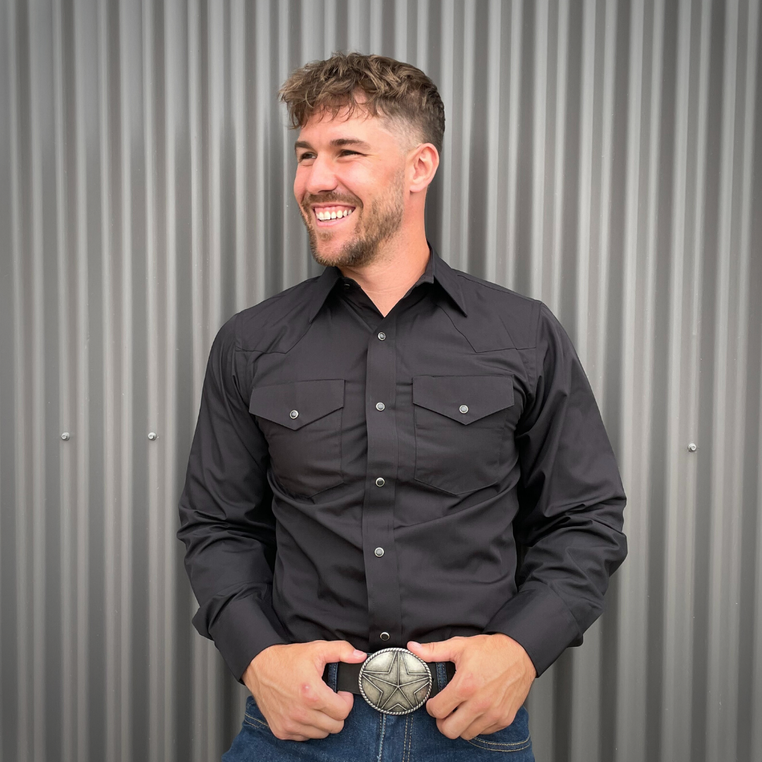 Men's long-sleeve western shirt. Western shirt is black with two front pockets and pearl snap buttons.