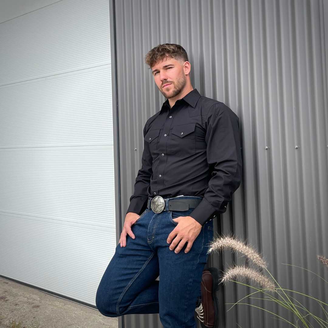 Men's long-sleeve western shirt. Western shirt is black with two front pockets and pearl snap buttons.