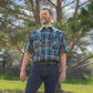 Men's short-sleeve plaid western shirt. Western shirt is teal, black and white with pearl snaps.